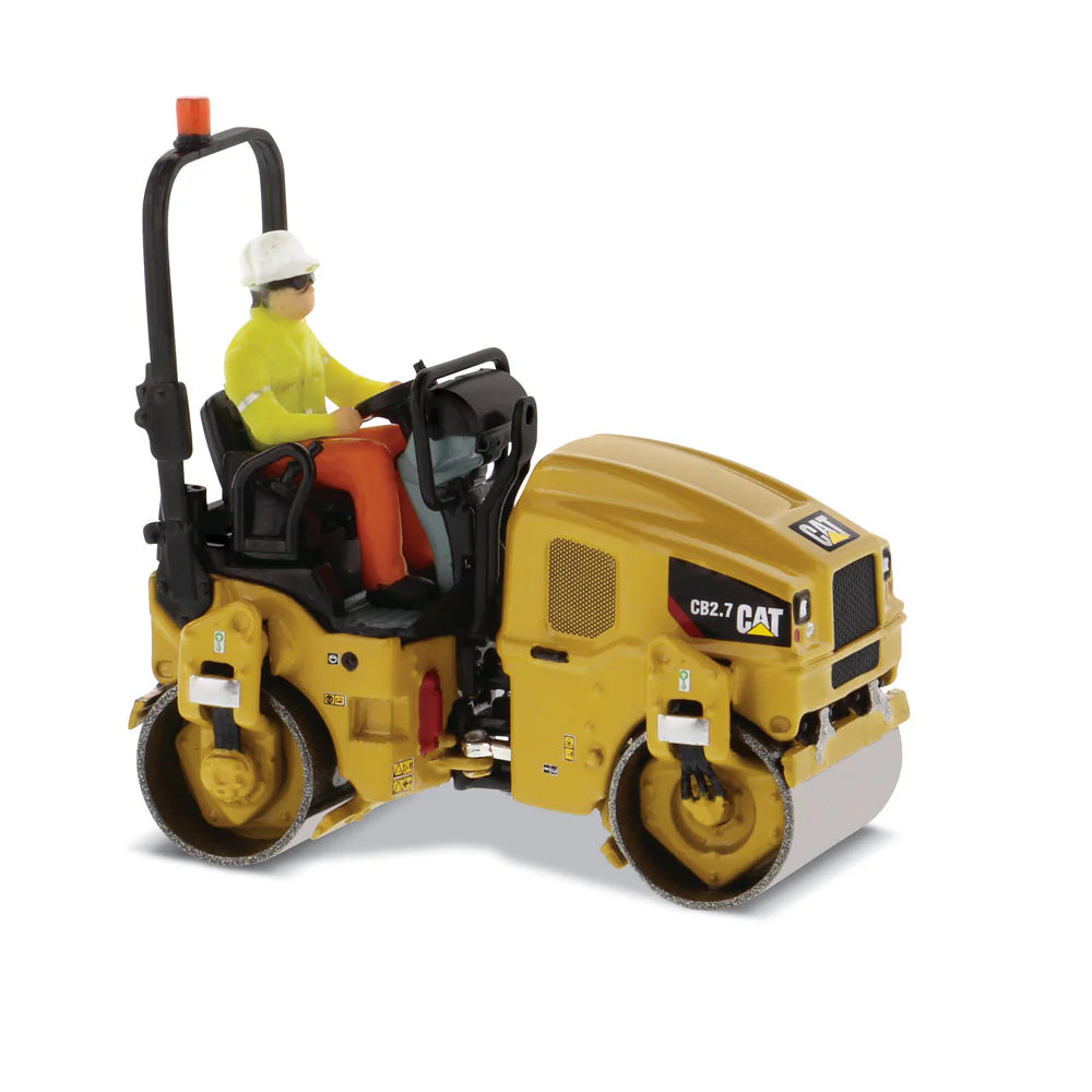 Model of a Caterpillar road roller with a driver figure on a white background